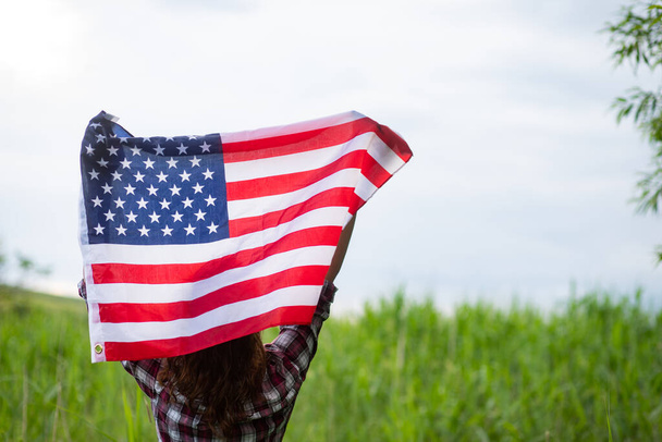 mujer sosteniendo día de independencia bandera de EE.UU.  - Foto, imagen