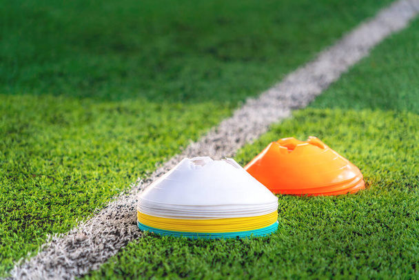 Pila de cono marcador Sport en campo de entrenamiento con campo verde y línea de boundry blanco
. - Foto, Imagen