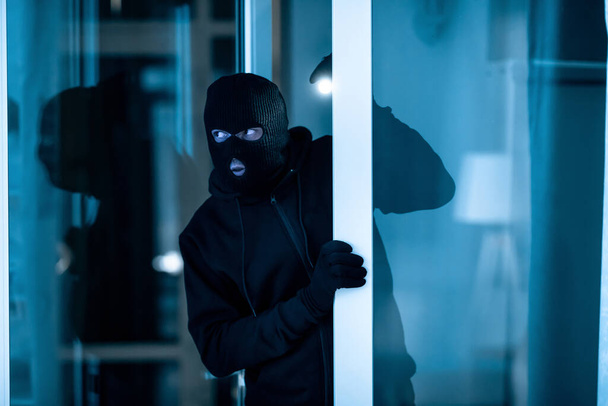 Κλέφτης που μπαίνει σε διαμέρισμα ή γραφείο για να κλέψει κάτι - Φωτογραφία, εικόνα