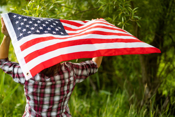 woman holding US flag independence day  - Foto, Imagen
