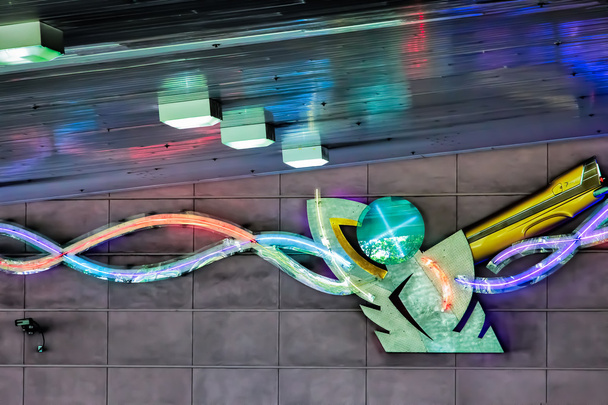 Ihmisen muotoinen neonvalo maanalaisessa pysäköintialueella
 - Valokuva, kuva