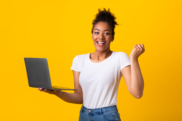 Excited female employee feeling ecstatic holding laptop - Фото, изображение