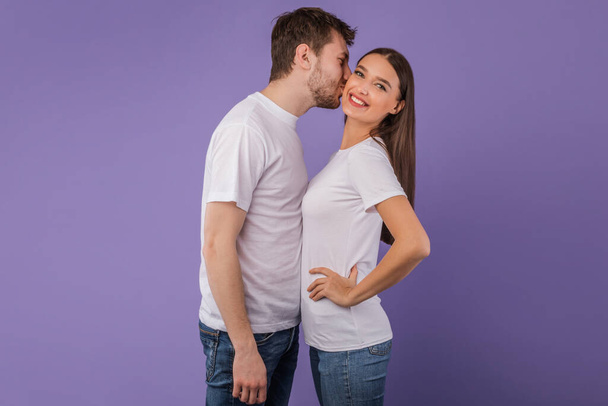 Portrait of beautiful young couple kissing at studio - Photo, Image