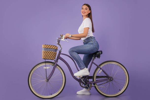 Hermosa mujer montando su bicicleta en el estudio, aislada
 - Foto, imagen