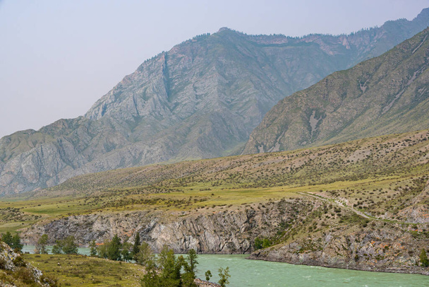 река в горной долине, поток воды между скалами и камнями с деревьями на берегу, водная туристическая поездка на плоту
 - Фото, изображение