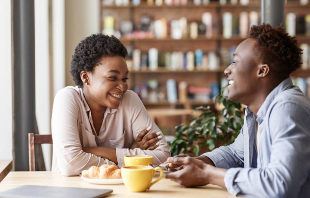 Knappe zwarte man met zijn mooie vriendin op eerste date in cafe - Foto, afbeelding