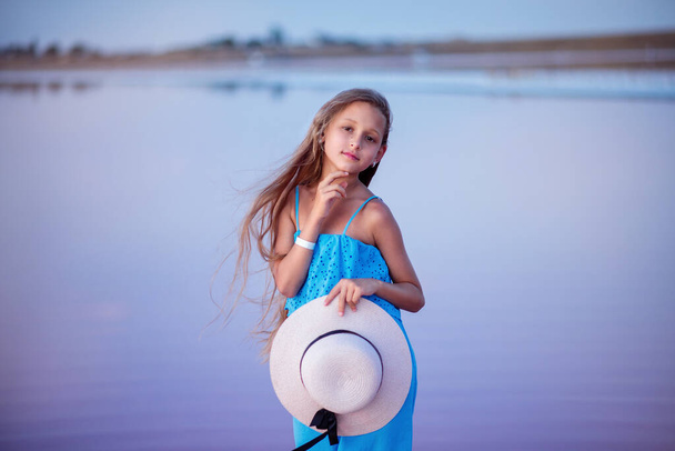 travels. beautiful girl on the lake. child on the beach. beautiful sunset. portrait of a child. long haired girl. relaxation and relaxation - Фото, изображение