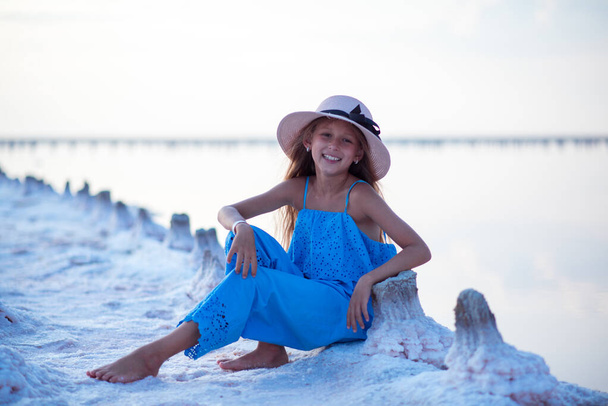 travels. beautiful girl on the lake. child on the beach. beautiful sunset. portrait of a child. long haired girl. relaxation and relaxation - Φωτογραφία, εικόνα
