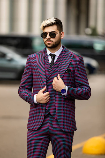 uomo d'affari in occhiali e lussuoso abito viola a tre pezzi, papillon in posa sulla strada - Foto, immagini