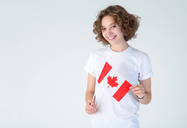 Portrait young girl student with the flag of Canada in hands. Beautiful Canadian woman. - Φωτογραφία, εικόνα