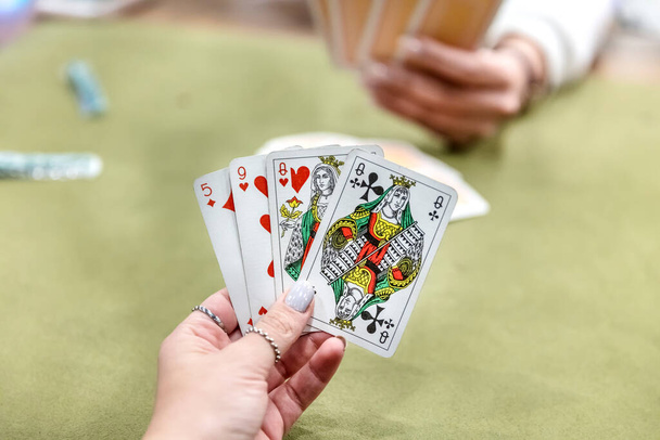 Woman playing cards. Shallow depth of field. Focus on hands holding cards. Room for text.  - Photo, Image