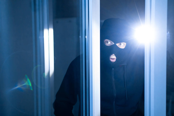 Наляканий злодій розбивається на квартиру, щоб вкрасти, використовуючи факел
 - Фото, зображення