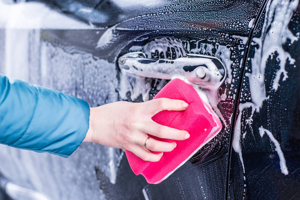 Dziewczyna sprzątanie samochodu z gąbką w myjni samochodowej, mycie samochodów - Zdjęcie, obraz