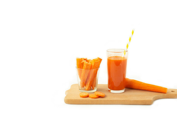 Bicchiere di succo di carota e carota fresca sul tagliere - Foto, immagini