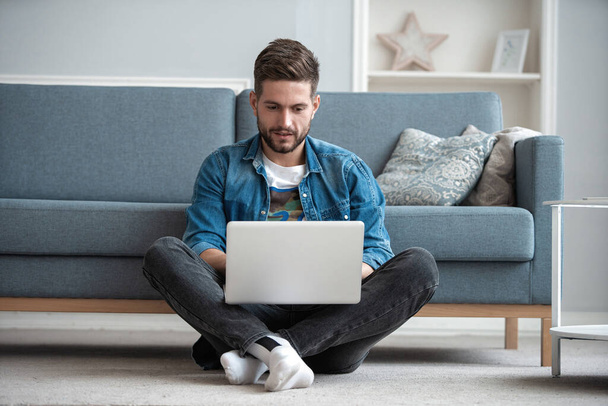 Handsome modern man designer working on laptop online, using internet at home - Фото, изображение