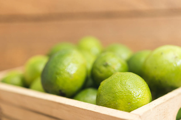 Fresh green lemons on wooden bottom - Fotoğraf, Görsel