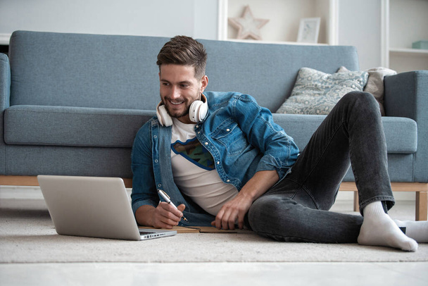 Handsome modern man designer working on laptop online, using internet at home - Φωτογραφία, εικόνα