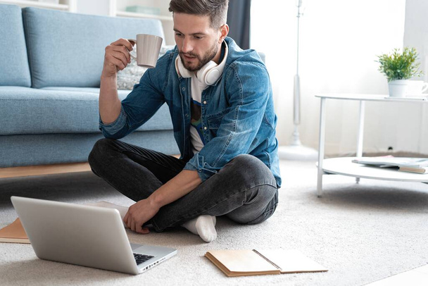 Handsome modern man designer working on laptop online, using internet at home - Fotó, kép