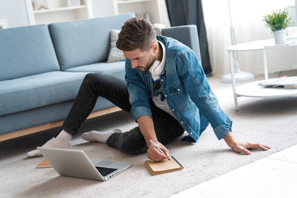 Handsome modern man designer working on laptop online, using internet at home - 写真・画像