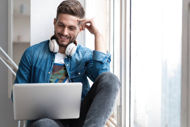 Handsome modern man designer working on laptop online, using internet at home - Foto, Bild