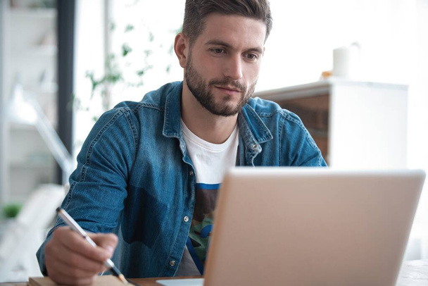 Handsome modern man designer working on laptop online, using internet at home - Fotografie, Obrázek