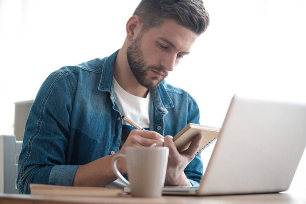 Handsome modern man designer working on laptop online, using internet at home - Photo, Image