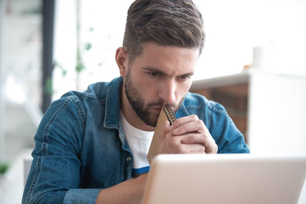 Handsome modern man designer working on laptop online, using internet at home - Фото, изображение