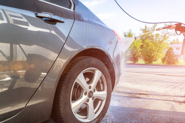 Auto waschen. Autowaschservice mit Wasser, Seife. Handgemachtes Auto aus Schaumstoff. Pflege mit Druckwachs. - Foto, Bild