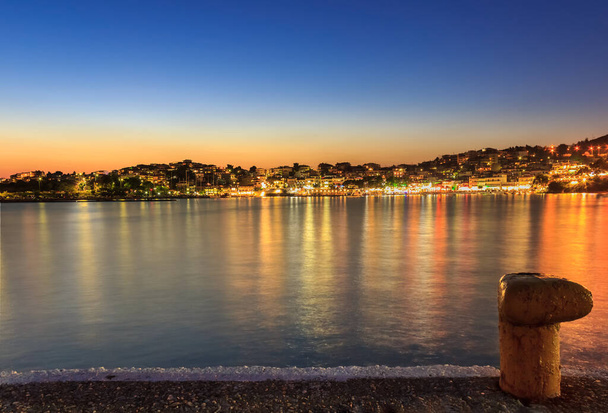 Cidade incrível de Neos Marmaras e porto vista do pôr-do-sol da hora dourada da doca com primeiro plano bollard
 - Foto, Imagem