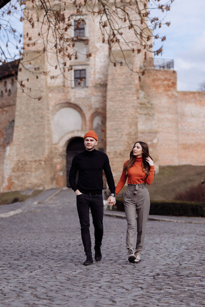 Beautiful Tourist Couple In Love Walking On Street Together. Happy Young Man And Smiling Woman Walking Around Old Town Streets, Looking At Architecture. Travel Concept. - Photo, Image