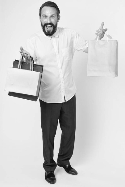 Keep smiling and carry on. Happy man hold shopping bags yellow background. Seasonal clearance sale. Sale and delivery. Mens clothing on sale. Shop for fashion. Because its sale, copy space - Fotoğraf, Görsel