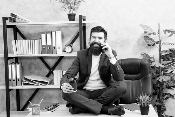 Lunch time is happy time. Mental wellbeing and relax. Man bearded manager formal suit sit lotus pose relaxing. Way to relax. Self care. Psychological help. Relaxation techniques. Mobile conversation - Foto, Imagem