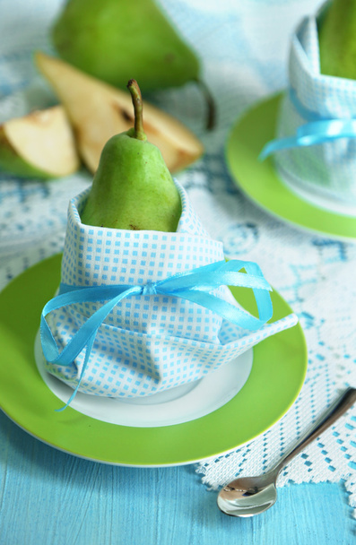 Pears in napkins on plates on wooden table close-up - Fotó, kép