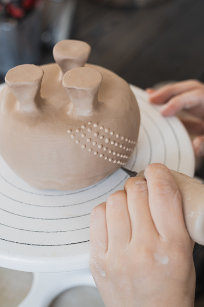 Молодая женщина прикрепляет глиняную деталь к будущей керамической продукции. Керамика. - Фото, изображение