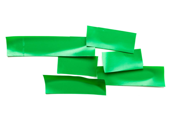 Adhesive sticky paper. Piece of green duct scotch tape isolated on white background. Torn strip grunge texture. - Photo, Image