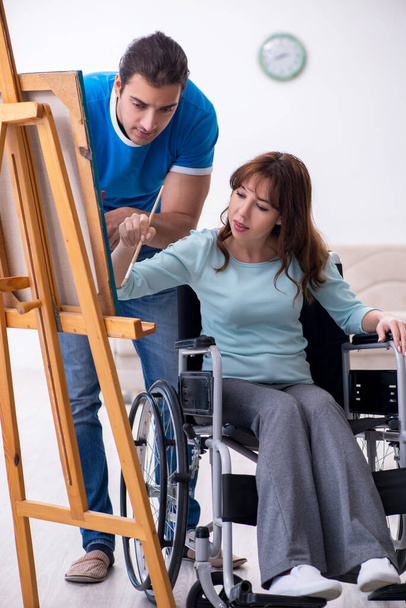 Disabled wife and young husband at home - Foto, afbeelding