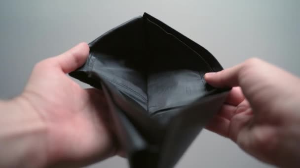 Malé drobné v černé kožené peněžence, muž ukazující prázdnou peněženku, mince v kabelce. Selhání obchodu a investic, pokles akciového trhu. Koncept finanční krize a nezaměstnanosti - Záběry, video