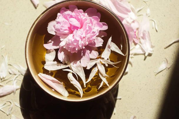 Peony lay in the water. Top view. Spa day. Natural perfume and cosmetics concept. - Photo, Image