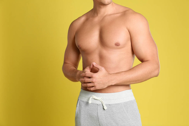 Man with sexy body on yellow background, closeup - Foto, Imagem