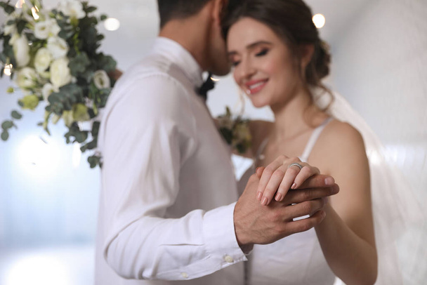 Happy newlywed couple dancing together in festive hall, focus on hands - Foto, Bild