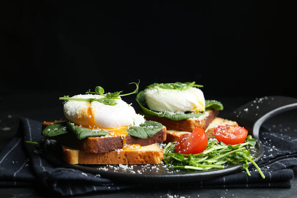 Delicious poached egg sandwiches served on slate board - Foto, Imagem
