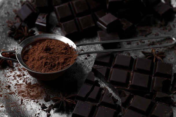 Delicious dark chocolate and cocoa powder on metal plate, closeup - Photo, image