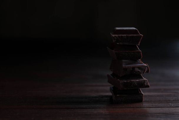 Delicioso chocolate negro sobre mesa de madera. Espacio para texto
 - Foto, imagen