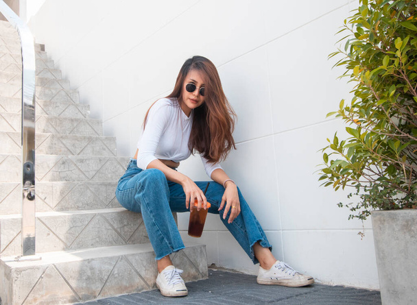 Outdoor portrait of a beautiful young  Asian young woman or girl with  wearing sunglasses - Photo, Image