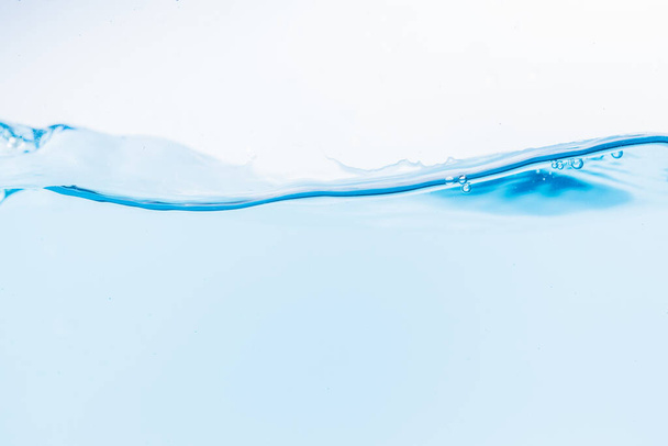 Surface of the blue water waves splash on a white background - Photo, Image