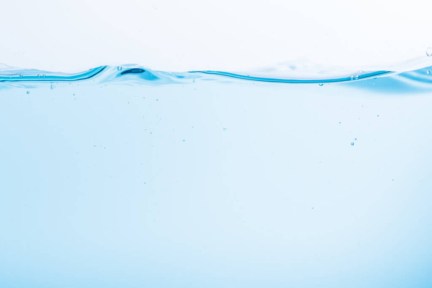 Oberfläche der blauen Wasserwellen plätschert auf weißem Hintergrund - Foto, Bild