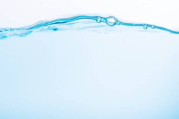 A kék vízhullámok felülete fehér alapon fröccsen - Fotó, kép