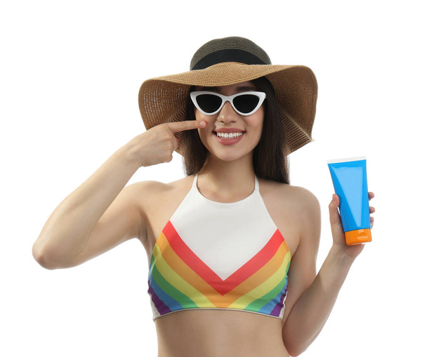 Mujer joven con crema de protección solar sobre fondo blanco
 - Foto, imagen