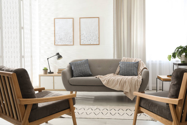 Modernes Wohnzimmer mit bequemen Sofas und Sesseln - Foto, Bild