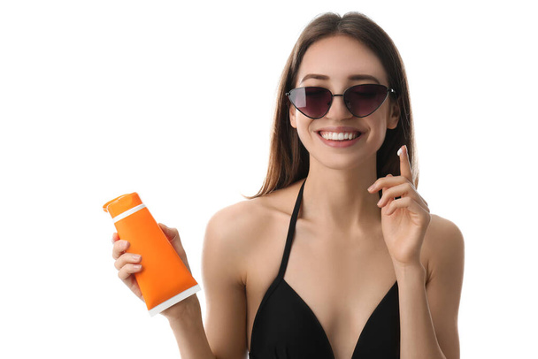 Young woman applying sun protection cream on white background - Φωτογραφία, εικόνα